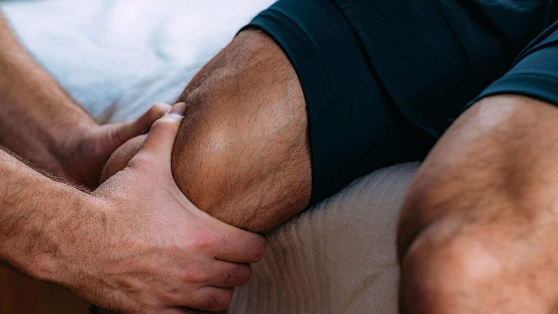 Medical professional examining knee during physical therapy or treatment